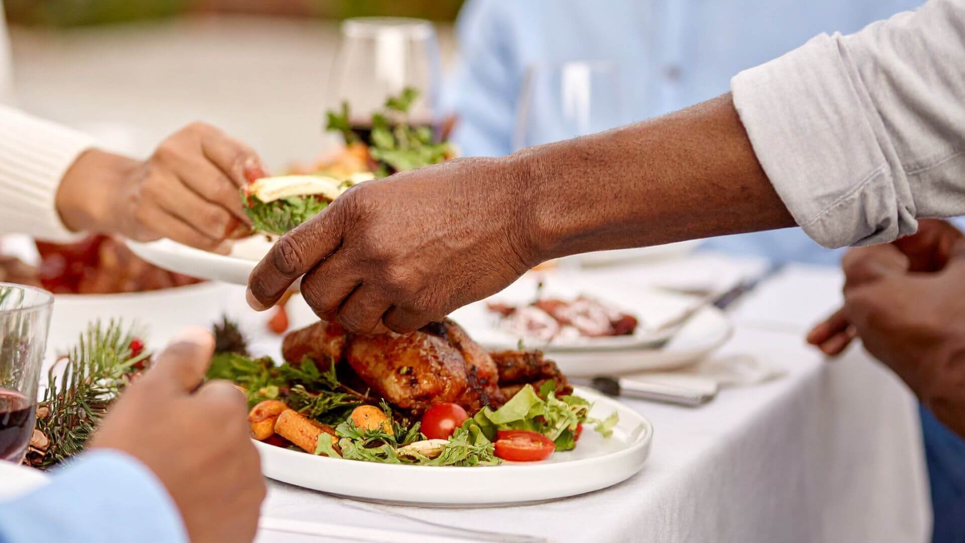 Hands grabbing food on table