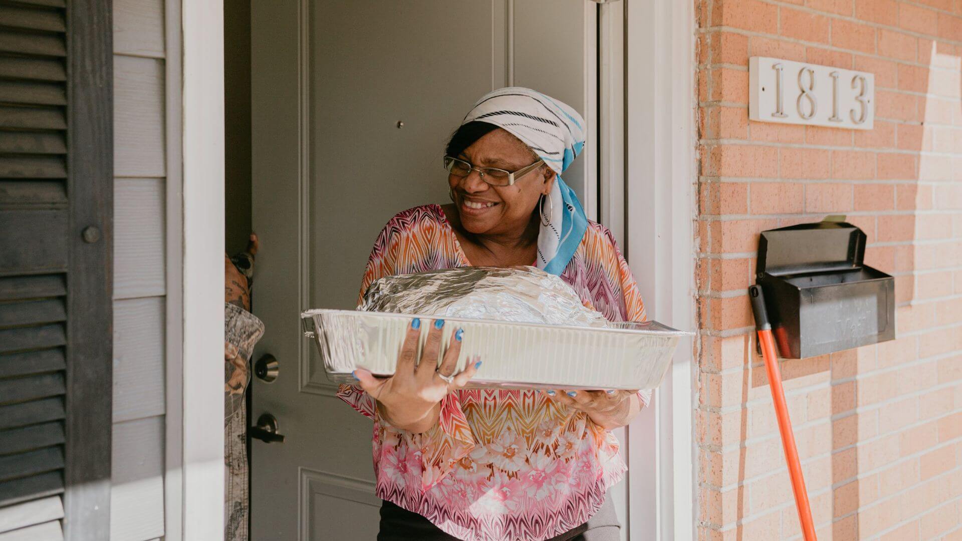 Woman walking out the door with large platter